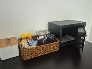a basket with coffee mugs next to a microwave at Dorothys in Pattaya South