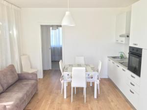 a kitchen and living room with a table and a couch at Villa Dune - Centrale - Immobil Relax in Lido di Jesolo +9 photos