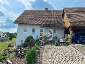 a white house with a brown roof at Ferienwohnung Rhön mit Terrasse im Grünen in Burkardroth