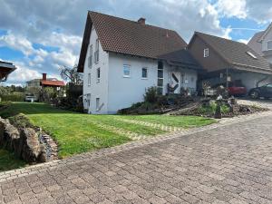 a house with a brick driveway in front of a house at Ferienwohnung Rhön mit Terrasse im Grünen in Burkardroth