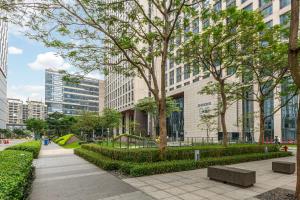 a park with benches and trees in a city at Bulgari Serviced Residences Guangzhou in Guangzhou