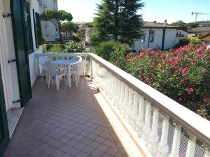 a balcony with a table and chairs and flowers at Villa Dune - Centrale - Immobil Relax in Lido di Jesolo