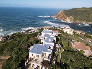 an aerial view of a house on a hill next to the ocean at Castle On The Heads in Knysna
