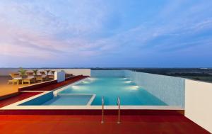 a swimming pool on the roof of a building at Gokulam Park Coimbatore in Coimbatore