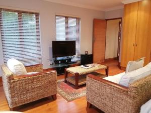 a living room with two chairs and a television at Castle On The Heads in Knysna