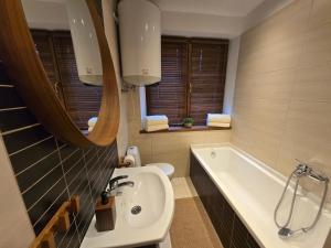 een badkamer met een wastafel en een ligbad bij Gniazdko Czarodzieja in Jedlina-Zdrój +23 foto's