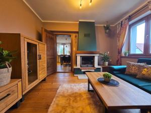 een woonkamer met een bank en een tafel bij Gniazdko Czarodzieja in Jedlina-Zdrój
