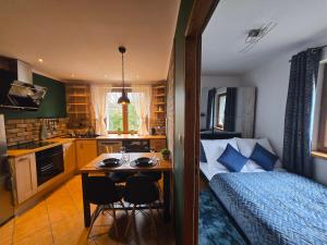 een slaapkamer met een bed en een keuken met een tafel bij Gniazdko Czarodzieja in Jedlina-Zdrój