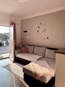 a living room with a couch and a clock on the wall at Apartment Laura in Senj