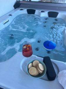 a hot tub with a plate of food and a glass of wine at Faber Penthouse in Bad Oeynhausen
