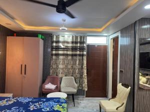 a bedroom with a bed and chairs and a sliding door at Urban Nest in Dehradun