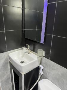 a bathroom with a sink and a toilet and a mirror at Studio5 in Munyonyo