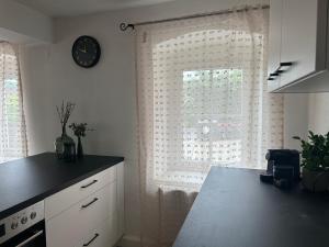 a kitchen with a window with a clock on the wall at FarawayHomes Studio Schwertberg #1 in Schwertberg