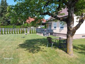 a table and chairs under a tree in a yard at Ferienhaus Käthe in Klagenfurt