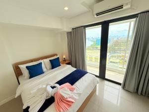 Un dormitorio con una cama grande y una ventana grande. en Sapphire Seaview Park Suites near Okada, Solaire, MOA, NAIA Airport, Bayview, en Manila 104 fotos más