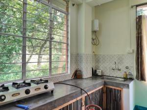 a kitchen with a stove and a sink and a window at Pine Forest Home stay with City View in Shillong