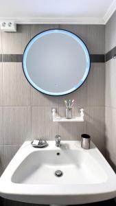 a bathroom with a white sink and a mirror at Rona Vista Suites amazing seaview 1 in Polykhrono