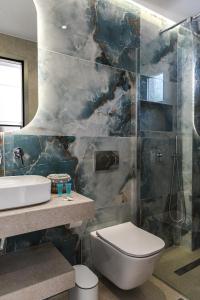 een badkamer met een toilet, een wastafel en een douche bij Porto Psakoudia in Psakoudia +55 foto's