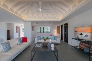 Petit Cul de SacにあるHilltop Deluxe Villa in Petit Cul De Sacのソファとテーブルのあるリビングルーム