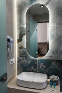 een badkamer met een wastafel en een spiegel bij Porto Psakoudia in Psakoudia