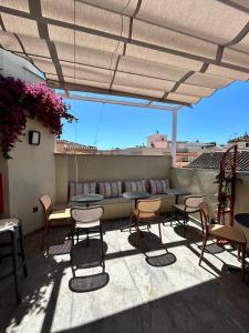 a patio with tables and chairs and a couch at El Mantenío in Málaga