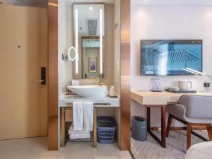 un bagno con un lavandino e un grande specchio di Lavande Hotel Shenzhen International Convention and Exhibition Center Fuhai West Subway Station a Shenzhen Altre 37 foto
