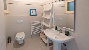 a white bathroom with a sink and a toilet at Villa Selva in Bellagio +41 photos