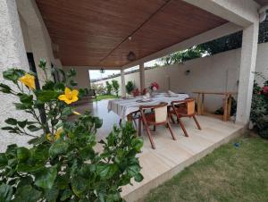 a patio with a table and chairs under a wooden roof at Villa La Balinaise in Lomé