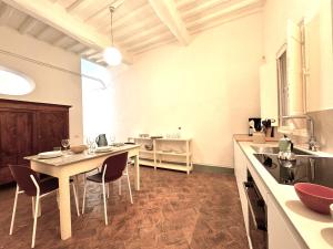 锡耶纳Pellegrini- Behind the Cathedral的房间里有一张桌子和几把椅子的厨房
