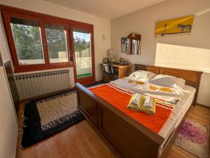 a bedroom with a large bed with orange sheets at Cozy room with a balcony in Sarajevo