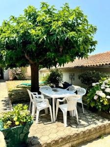 a white table and chairs under a tree at Maison avec jardin et proche mer in Propriano