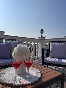 two glasses of wine and a vase of flowers on a table at Apartment Laura in Senj