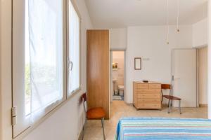 a bedroom with a bed and a window and a dresser at Villa Terra Rossa in Torre San Giovanni Ugento