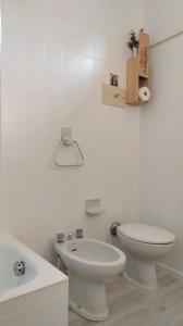 een witte badkamer met een toilet en een wastafel bij Vesto VISTA in Marone