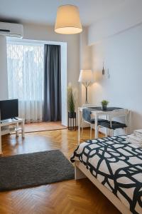 Una sala de estar con una cama y un comedor. en Studio Confort, en Bucarest