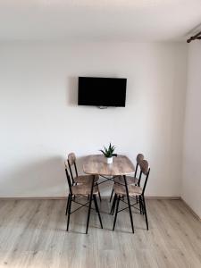 stół jadalny z krzesłami i telewizor na ścianie w obiekcie Apartment Metajna 6465a w mieście Metajna