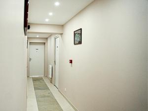 a hallway with a white wall and a door at Hôtel-Restaurant Belle'man in Longevelle-sur-Doubs