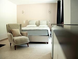 a bedroom with a bed and a chair and a chair at Hôtel-Restaurant Belle'man in Longevelle-sur-Doubs
