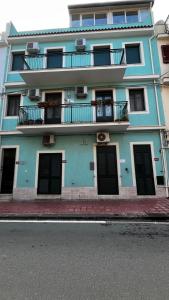 a blue building with black doors and a balcony at Casa Nicole - Letojanni Taormina in Letojanni