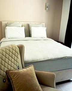 a large bed with white sheets and pillows at Hôtel-Restaurant Belle'man in Longevelle-sur-Doubs
