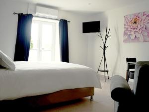 a bedroom with a large bed and a window at Hôtel-Restaurant Belle'man in Longevelle-sur-Doubs