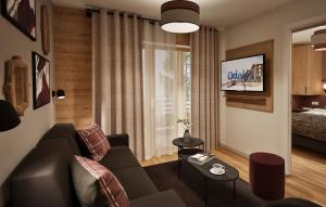 una sala de estar con un sofá y una mesa en Hotel L'Ecrin Blanc by Odalys, en La Rosière 24 fotos más