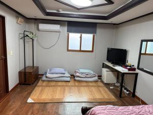 um quarto com duas camas, uma escrivaninha e uma televisão em Samsung Hotel em Gangneung