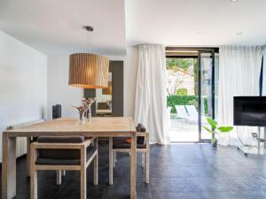 a dining room with a table and a tv at Sunset House by Hello Homes Sitges in Sitges