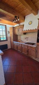 Una cocina con gabinetes de madera y un horno de estufa. en Gîte Douce Quiétude, en Barbey-Séroux