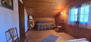 una sala de estar con sofá en una cabaña de madera en Gîte Douce Quiétude, en Barbey-Séroux