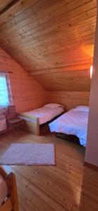 Un dormitorio con dos camas en una cabaña de madera. en Gîte Douce Quiétude, en Barbey-Séroux