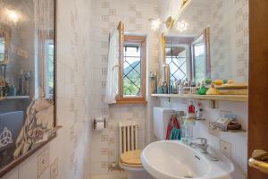 a bathroom with a sink and a toilet and windows at Vacanza Natura, Montagne e Laghi in Omegna +25 photos