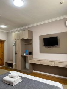 Una sala de estar con un televisor de pantalla plana en una pared. en MASSAGET HOTEL, en Nukus