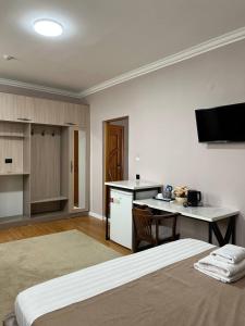Habitación con cama, escritorio y cocina. en MASSAGET HOTEL, en Nukus